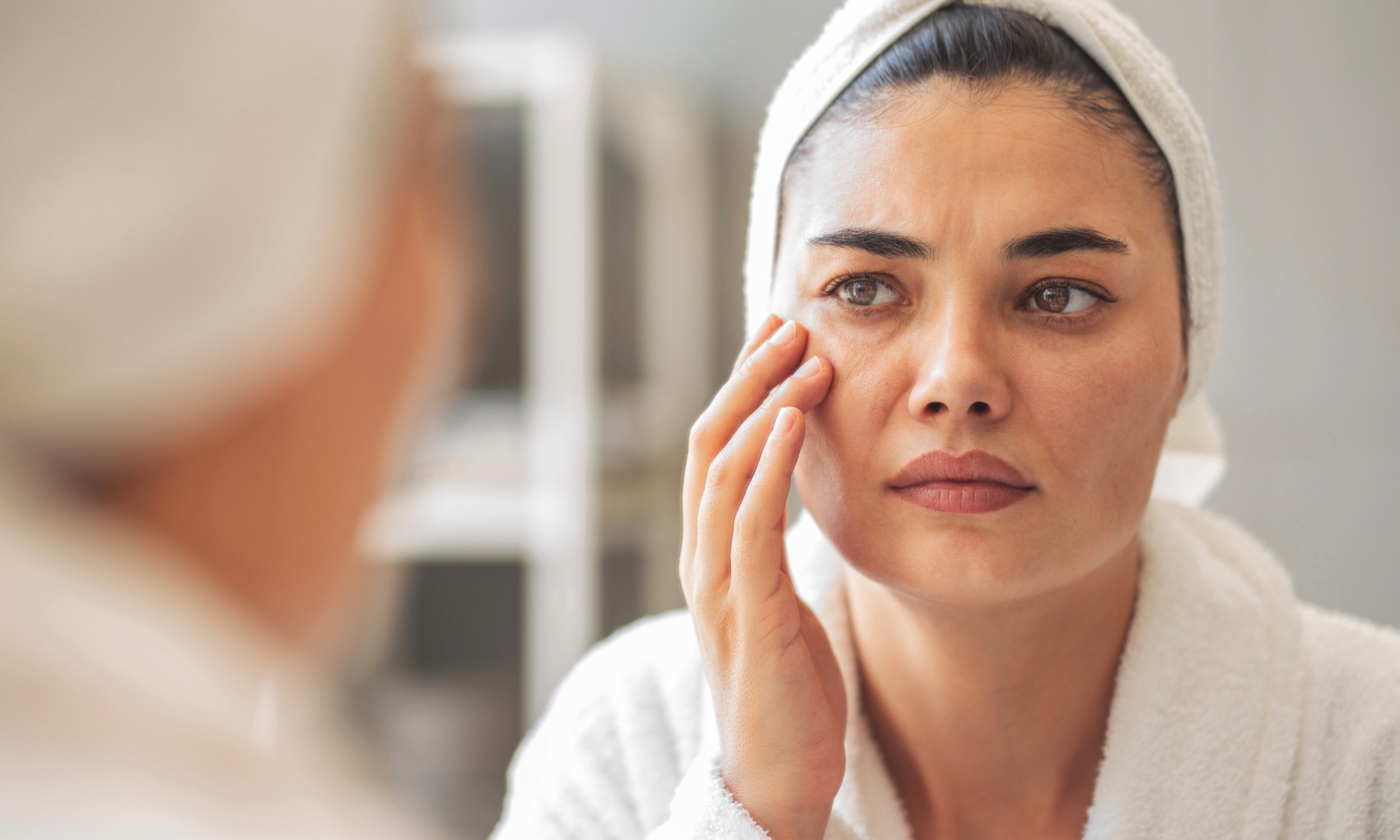 Na sliki je portret temnolase gospe srednjih let. Na glavi ima turban iz bele brisače, ovita je v bel kopalni plašč. V ogledalu opazuje svojo kožo in prve gube.